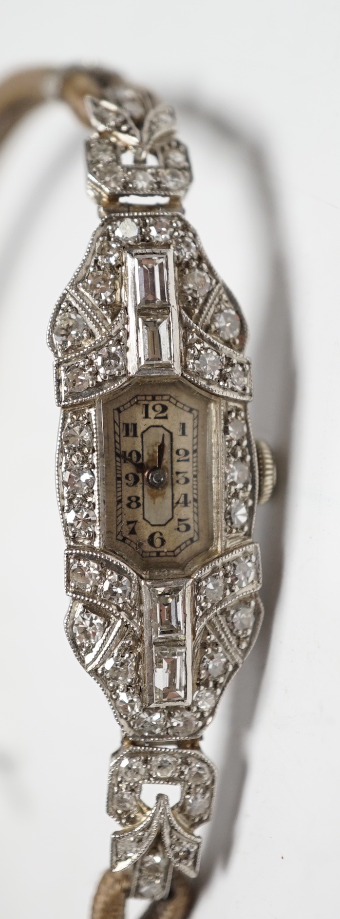A lady's 1940's/1950's white metal (engraved platinum) and diamond cluster set manual wind cocktail watch, on a twin fabric strap.